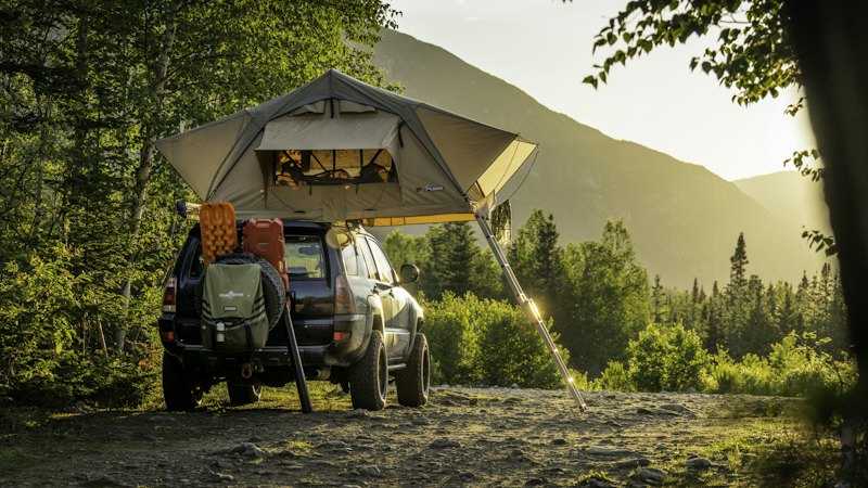 4x4 équipé d’une tente de toit dans une vallée de montagne